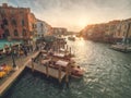 Venice, Italy - 17.10.2023: Busy water traffic with boats, taxi and gondolas in Rialto bridge area of the Grand channel. Warm