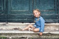 Venice, Italy. A charming 4 year old girl in a blue dress plays in an old Venetian courtyard, sits on warm marble steps and laughs Royalty Free Stock Photo