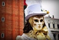 VENICE, ITALY - Feb 09, 2016: A Venetian golden mask masquerade in costume at the carnival of Venice