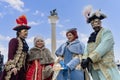 A group of participants in original costumes of the Venice Carnival on the embankment