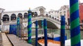 VENICE, ITALY - FEBRUARY 23, 2017: Panoramic view of Canal Grande with pole to mooring green and blue and the Rialto Bridge on the