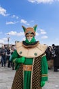 Participant of the Venice Carnival in an original green costume with gold decorations