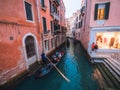 Venice, Italy - 17.10.2023: Gondolas with tourists passing slowly in a small channel between stunning old buildings of the city. Royalty Free Stock Photo