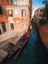 Venice, Italy - 17.10.2023: Gondolas waiting for passengers, Stunning colorful buildings in the background. Warm sunny day. Travel