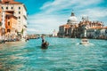 Venice, Italy. Gondolier looking for next tourists on Grand Canal. Basilica Santa Maria della Salute against blue sky Royalty Free Stock Photo