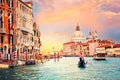 Sunset in Venice, Italy. Boat and gondola on Grand Canal with Basillica Santa Maria della Salute in the background. Royalty Free Stock Photo