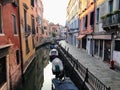 An early morning view of a quiet narrow old canal in Venice, Italy.  The ancient venetian architecture lines the canal. Royalty Free Stock Photo