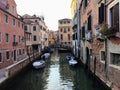 An early morning view of a quiet narrow old canal in Venice, Italy.  The ancient venetian architecture lines the canal. Royalty Free Stock Photo