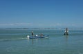 VENICE, ITALY - Jun 19, 2018: Three men in a small boat on the lagoon, in Venice, Italy