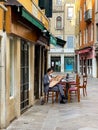 VENICE, ITALY - JUNE 2021: A lonely man in a medical mask is having breakfast in an empty Venice