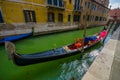 VENICE, ITALY - JUNE 18, 2015: Parking gondola in Venice canal, ready to be used. Water transporation
