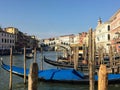 A classic view looking past wooden jetties and gondolas towards the Rialto Bridge in Venice, Italy along the Grand Canal on a beau Royalty Free Stock Photo