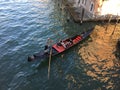 close up overhead view of a gondolier paddling his gondola with a pair of tourists along the waters of a canal in Venice, Italy