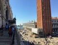 A group of tourists on the balcony of saint marks basilica beside the horses of saint mark, taking photos and admiring the views