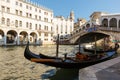 View of gondola and Ponte di Rialto, many tourists on a bridge. Sunset in Venice Royalty Free Stock Photo