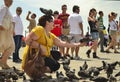 VENICE, ITALY- JUNE 30, 2011: Woman tourist holding pigeons in square San Marco