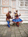 Venice, Italy - March 1, 2019 A couple is dressed with an Arlequin costume