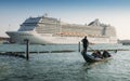 Juxtaposition of gondola and huge cruise ship in Giudecca Canal. Old and new transportation on the Venice Lagoon Royalty Free Stock Photo