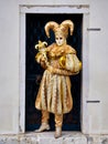 Venice, Italy - March 1, 2019 A person dressed with a gold Arlequin costume Royalty Free Stock Photo