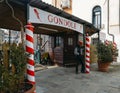 Gondolier relaxes next to a sign advertising gondola riding Services Royalty Free Stock Photo