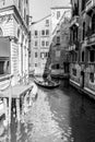 Venice, Italy - March 11, 2012: Typical Gondola with gondolier rowing along a narrow canal in Venice, black and white image Royalty Free Stock Photo