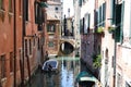 Canal streets of Venice with motorboats anchored at walls of old houses.