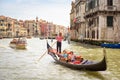 Gondola with people sails on Grand Canal in sunny Venice