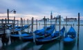 Venice, Italy - 20 May 2105: Gondolas moored on the lagoon, with Royalty Free Stock Photo