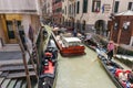 Goods and materials transported and delivered by boat in narrow canals with gondola and tourists