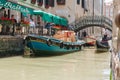Goods and materials transported and delivered by boat in narrow canals with gondola and tourists