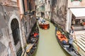 Goods and materials transported and delivered by boat in narrow canals with gondola and tourists