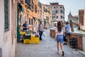 Picturesque Scene from Venice with people walking on the cobblestone alley near water canals in Venice