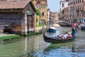 Scene from Venice with stone bridges over the water canals and the the tourists enjoying a gondola Royalty Free Stock Photo