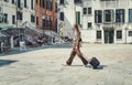 Solo female traveller with a luggage trolley bag walking on the cooblestone streets of Venice