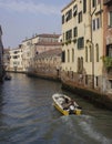 Traditional canal in Venice with motoboat crossing it Royalty Free Stock Photo