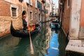 Gondola floats through narrow canal of Venice, Italy