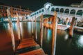 Venice, Italy. A night-time view of pier at iconic Rialto Bridge, spanning over the Grand Canal lit by city illumination Royalty Free Stock Photo