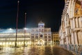 Venice Italy night view of St Marks Clock tower on the homonymous square, with a side view of St Marks Basilica entrance. Royalty Free Stock Photo