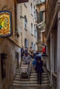 People walking on narrow staircase between buildings in the city of Venice, Italy