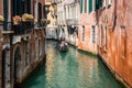 Gondolier on a gondola on canal street in Venice, Italy