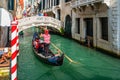 Gondolier on a gondola on canal street in Venice, Italy