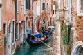 Gondolier on a gondola on canal street in Venice, Italy