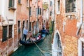 Gondolier on a gondola on canal street in Venice, Italy