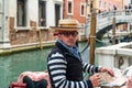 Gondolier on a gondola on canal street in Venice, Italy