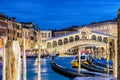 Venice, Italy. Rialto bridge and Grand Canal at twilight blue hour. Gondolas on the foreground. Tourism and travel concept. Royalty Free Stock Photo