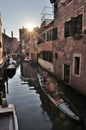 VENICE, ITALY - Sep 23, 2016: typical scene on a canal in Venice, a venetian gondola with gondoliere and tourists at sunset