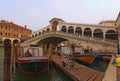 The process of unloading cargo boat by porters. Ancient Rialto Bridge over Grand Canal