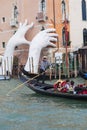 Support Sculpture by Lorenzo Quinn putting two giant hands protruding from the Grand Canal water, Venice, Italy