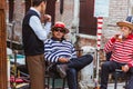 VENICE, ITALY - SEPTEMBER 22, 2017 :Two gondoliers in traditional costumes on the bridge during a rest break