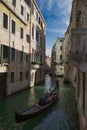 Venice, Italy: Vertical wide angle shot of Picturesque view of Gondolas on lateral narrow Canal with nearly